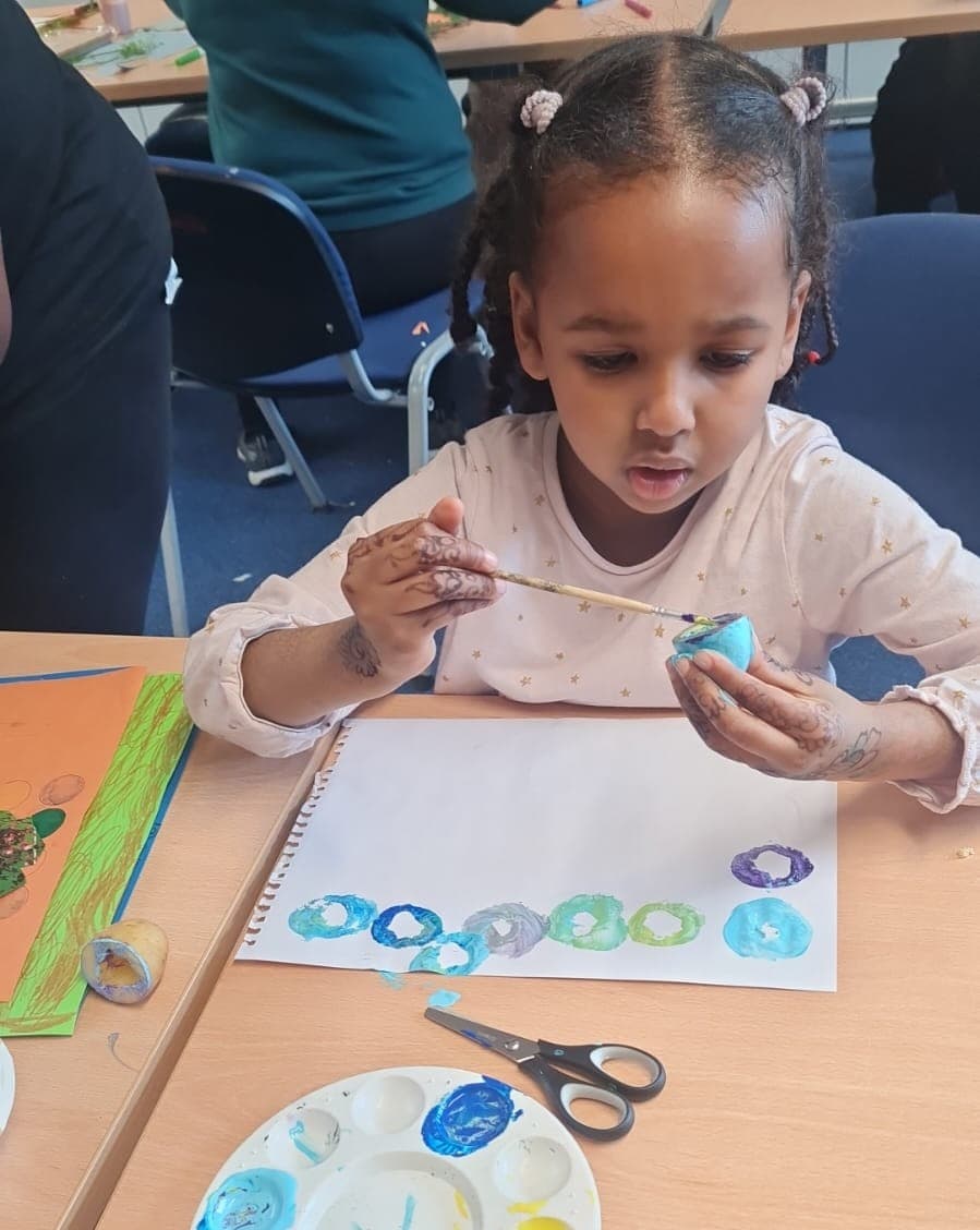 A young member painting at an Arts & Craft session