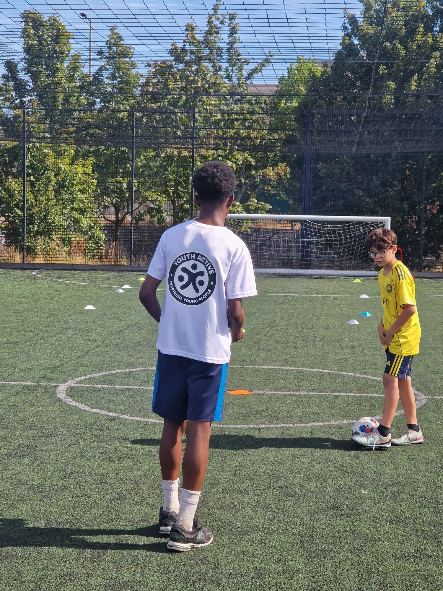 Young people running football drills at a Youth Active session